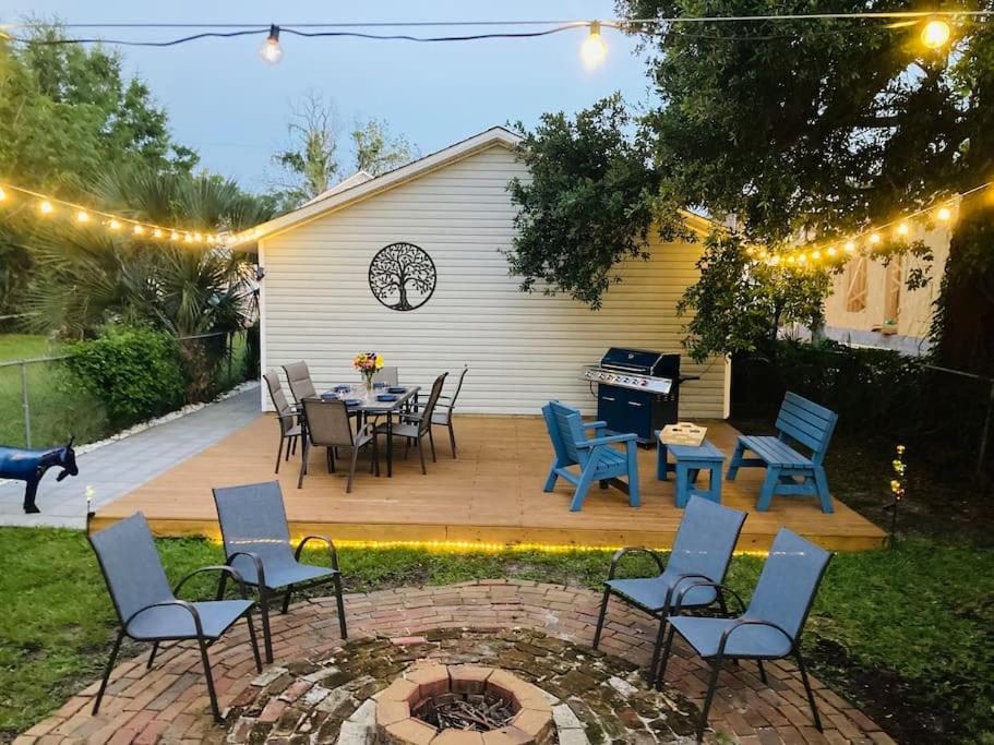 un patio con mesa, sillas y piano en Pensa-Cozy Downtown bungalow, w/ backyard oasis! en Pensacola