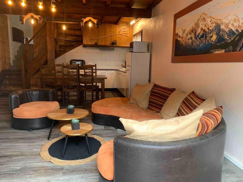 ein Wohnzimmer mit einem Sofa und Tischen sowie eine Küche in der Unterkunft Maison de montagne in Auzat
