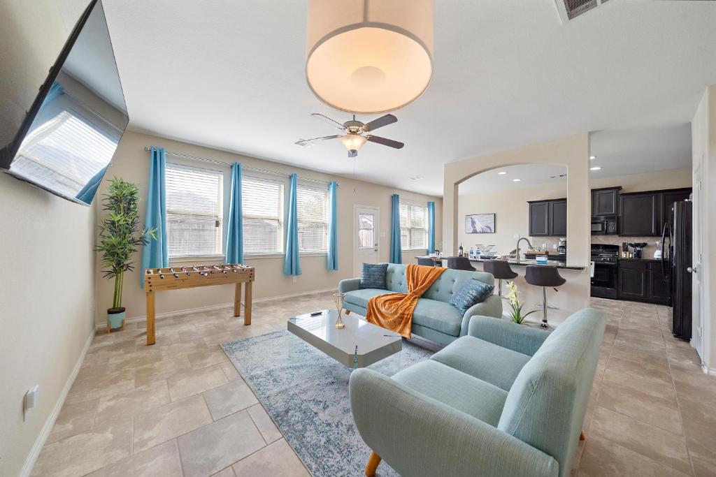ein Wohnzimmer mit blauen Sofas und eine Küche in der Unterkunft Houston Home Nr Iah Games Wi-fi Bbq Yard in Houston