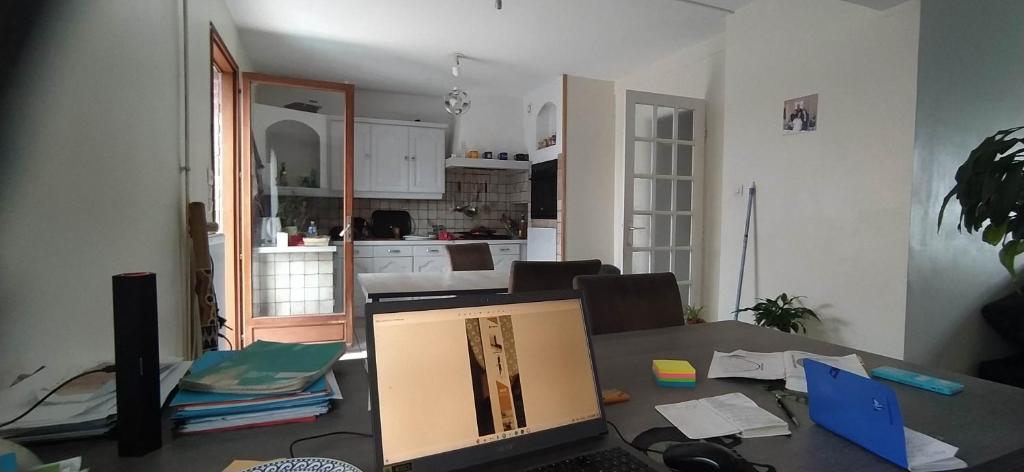ein Zimmer mit einem Tisch und einem Computer darauf in der Unterkunft Chez Laurent in Mérignies
