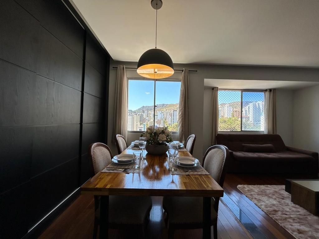 a dining room with a table and chairs and a couch at Apartamento em Belo Horizonte 2 in Belo Horizonte