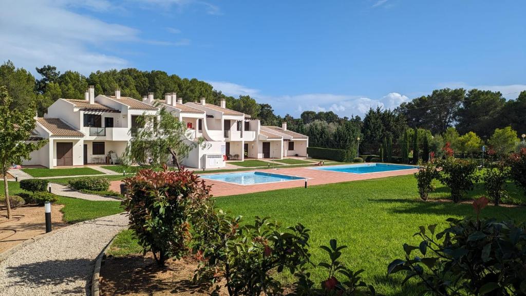 a large house with a yard with a swimming pool at Apartamento com terraços privativos em resort de luxo, By QoZzy in Alvor