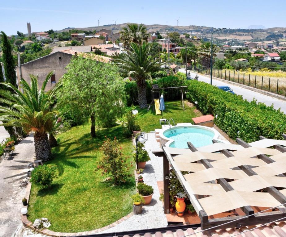 an apartment with a swimming pool and palm trees at Simo Amour in Lercara Friddi