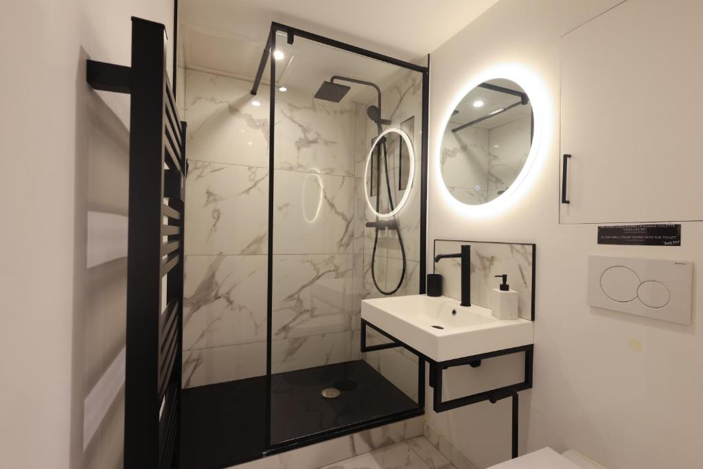 a bathroom with a shower and a sink and a mirror at Villa Corbelle - Grand Studio in Cannes