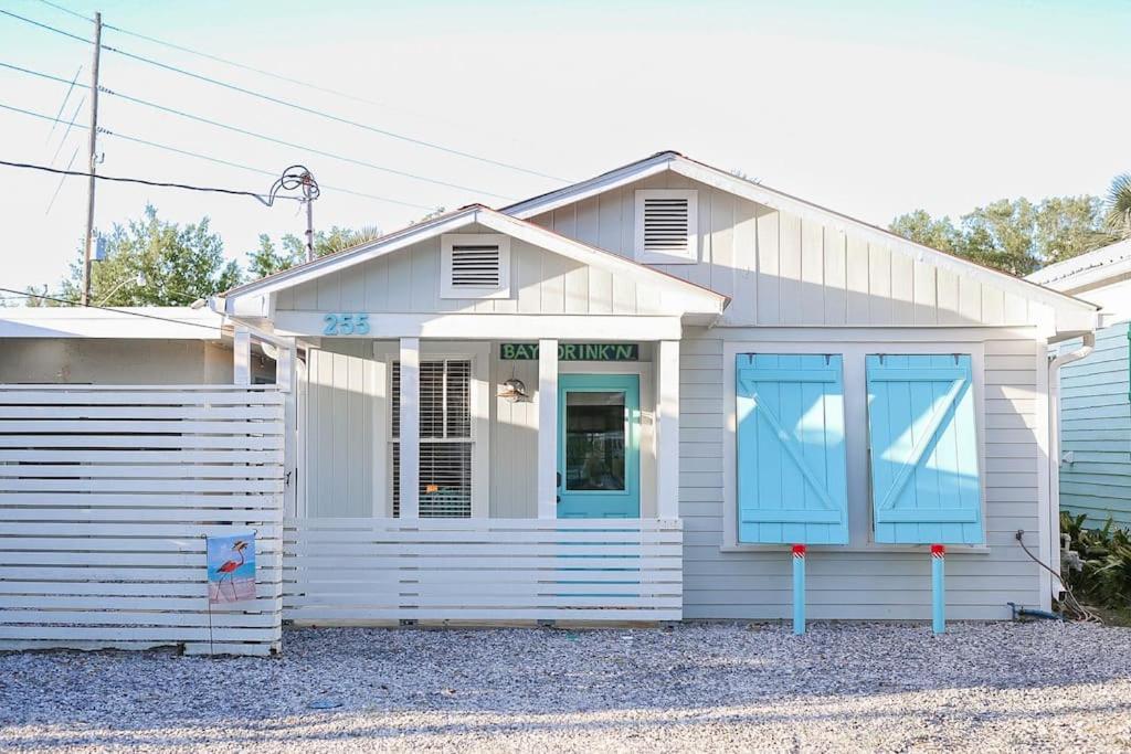 una casa blanca con puertas azules en una calle en Lost At Sea, en Bay Saint Louis