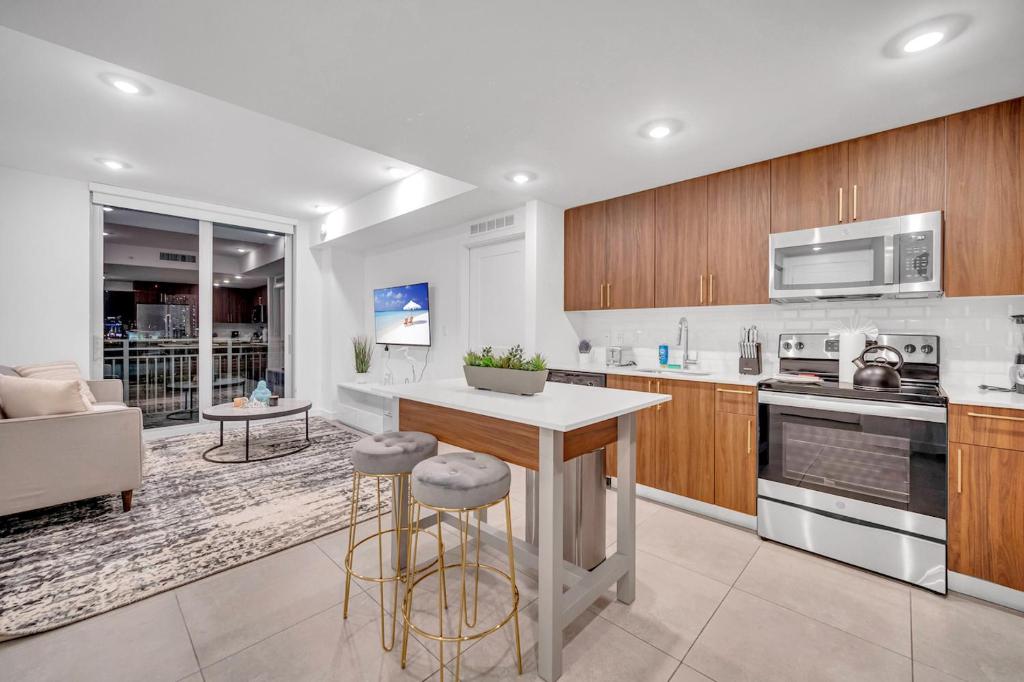 a kitchen with wooden cabinets and a kitchen island with bar stools at Exclusive Condo in Downtown Miami With Pool Views and Free Parking in Miami