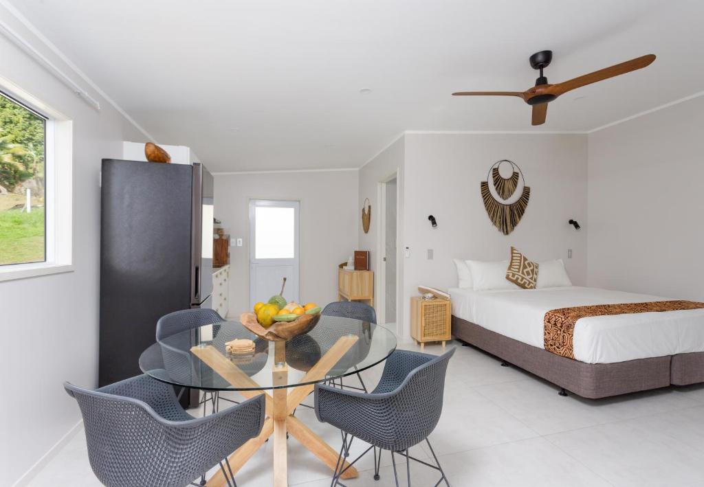 a bedroom with a table and chairs and a bed at Studio Varia in Rarotonga