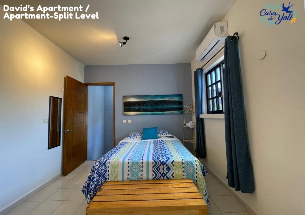 a bedroom with a bed with a bench in it at Casa de Yoli in Cozumel