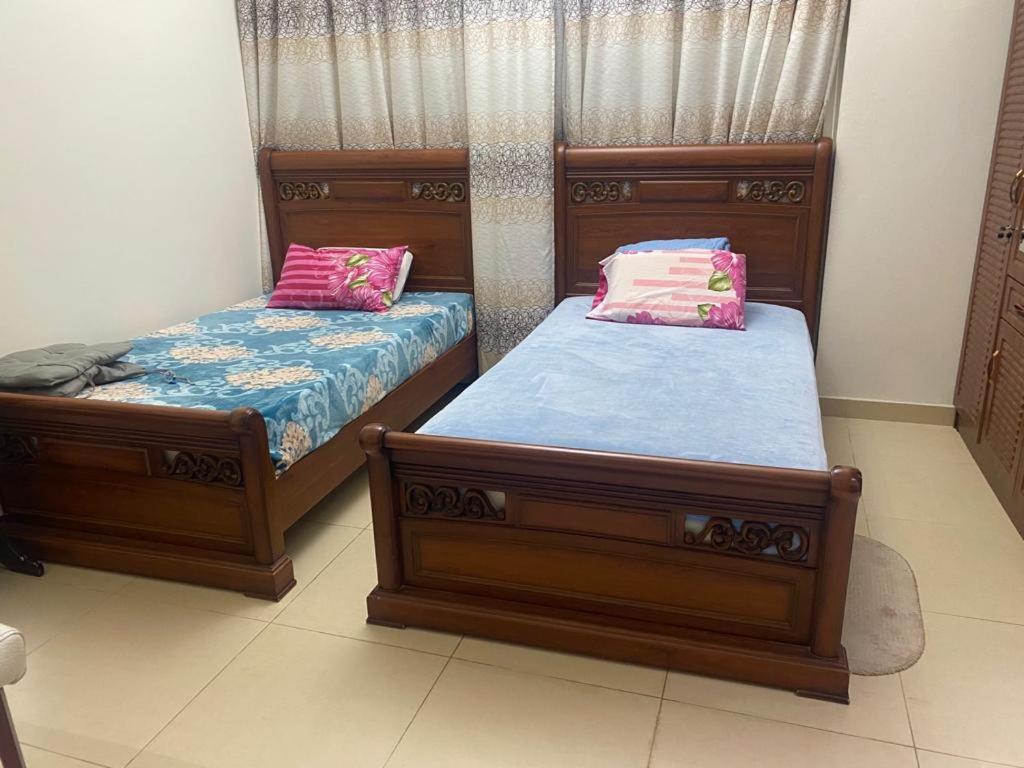 two beds sitting next to each other in a room at Al Yasmeen Tower A in Ajman 