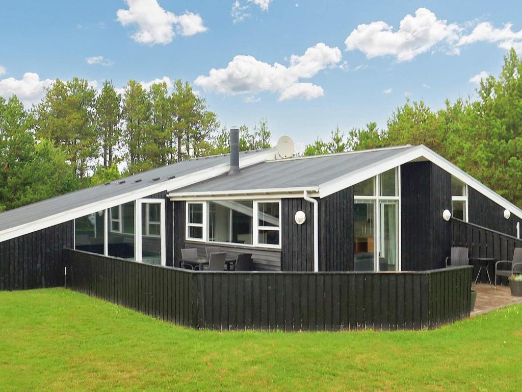 een zwart huis met een schuin dak bij Holiday home Jerup LX in Jerup