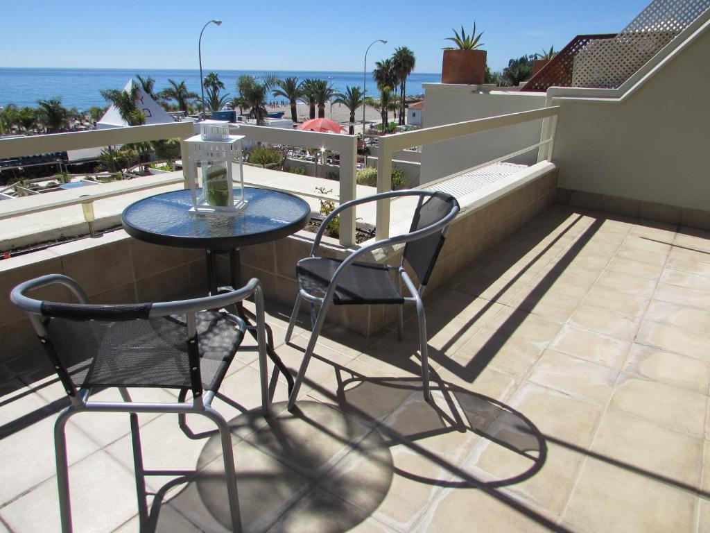 a table and chairs on a balcony with the ocean at Home4Holidays in Nerja