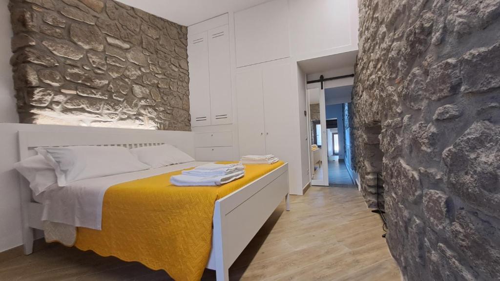 a bedroom with a bed and a stone wall at Alloggio turistico Pietra Viva in Vitorchiano