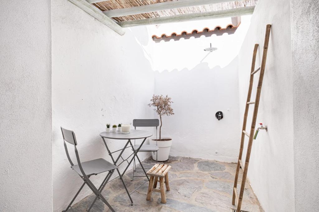 Habitación con mesa, sillas y escalera. en Casa do Largo - Lago do Alqueva, en Campinho