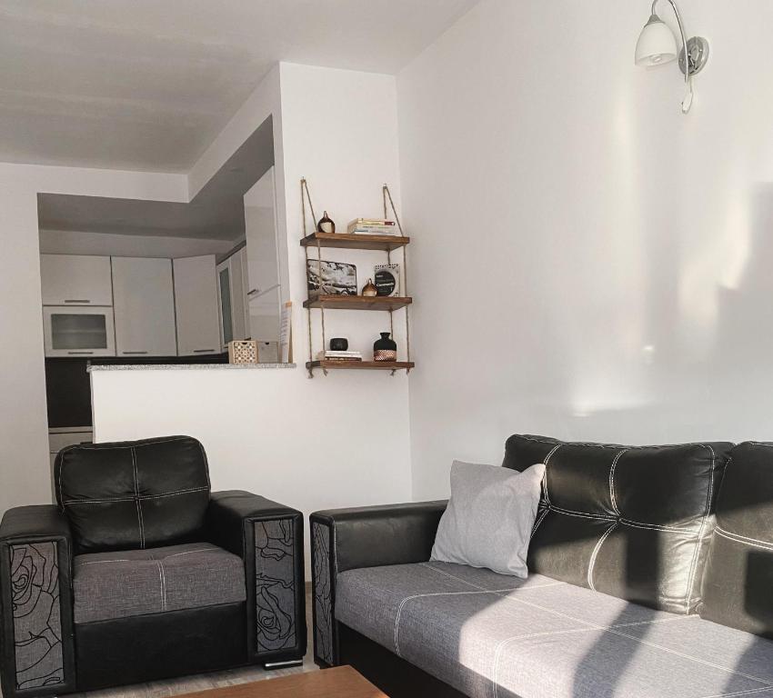 uma sala de estar com duas cadeiras e um sofá em Private Apartment Prishtina em Pristina