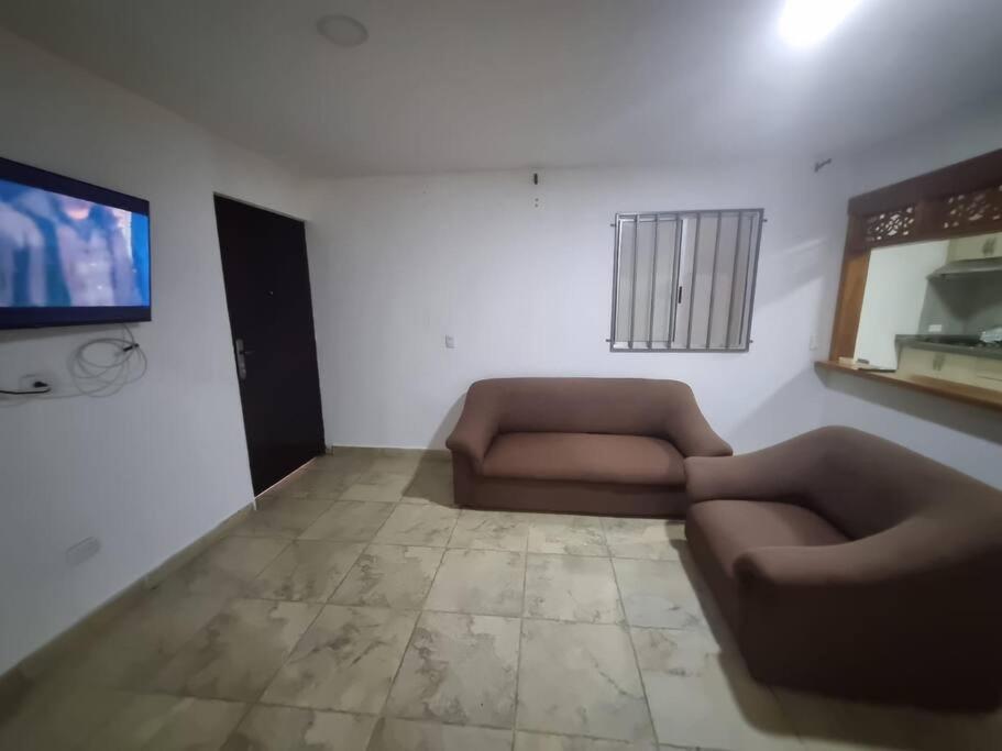 a living room with two couches and a flat screen tv at casa antioquia in Circasia