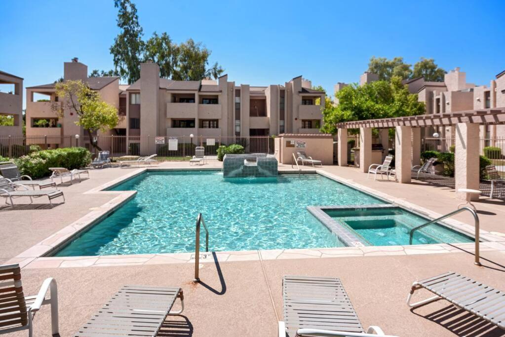a large swimming pool with chairs and a building at Cozy 1bd in of Old Town Heated HotTub in Scottsdale
