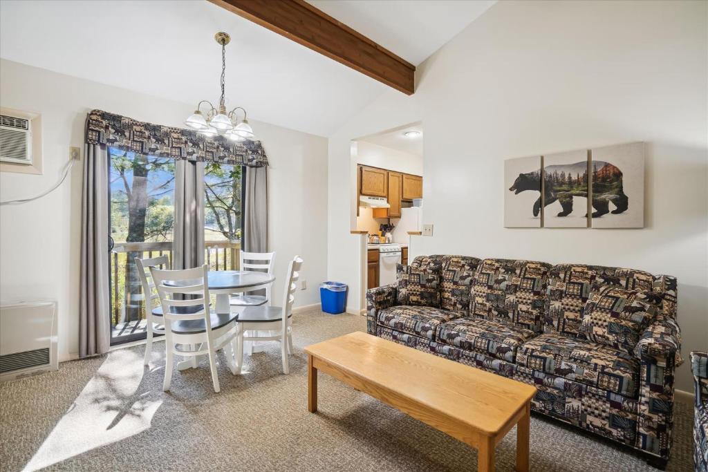 uma sala de estar com um sofá e uma mesa em Cedarbrook Queen Suite 203 em Killington