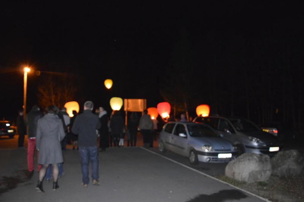 een groep mensen die 's nachts over straat lopen bij le moulin in Le Monastier sur Gazeille