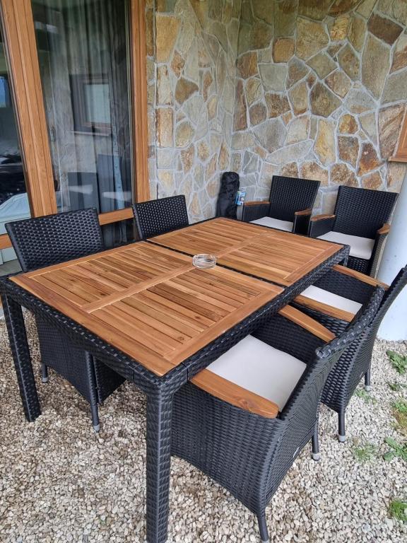 a wooden table and chairs on a patio at Domek z kominkiem nad jeziorem Czorsztyńskim in Frydman