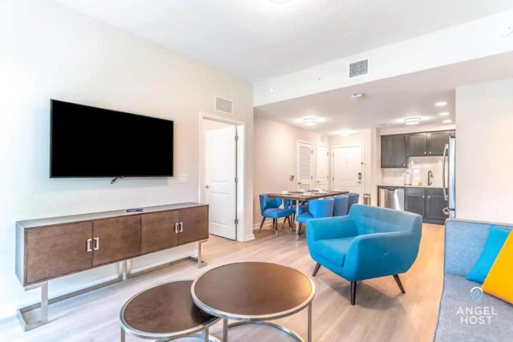 ein Wohnzimmer mit einem Flachbild-TV und blauen Stühlen in der Unterkunft TVPM-4001#107BD VC apts in Orlando