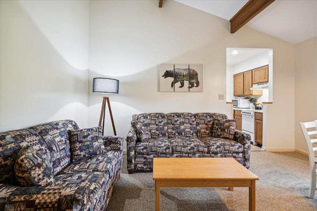 a living room with a couch and a table at Cedarbrook Queen Suite 202 in Killington