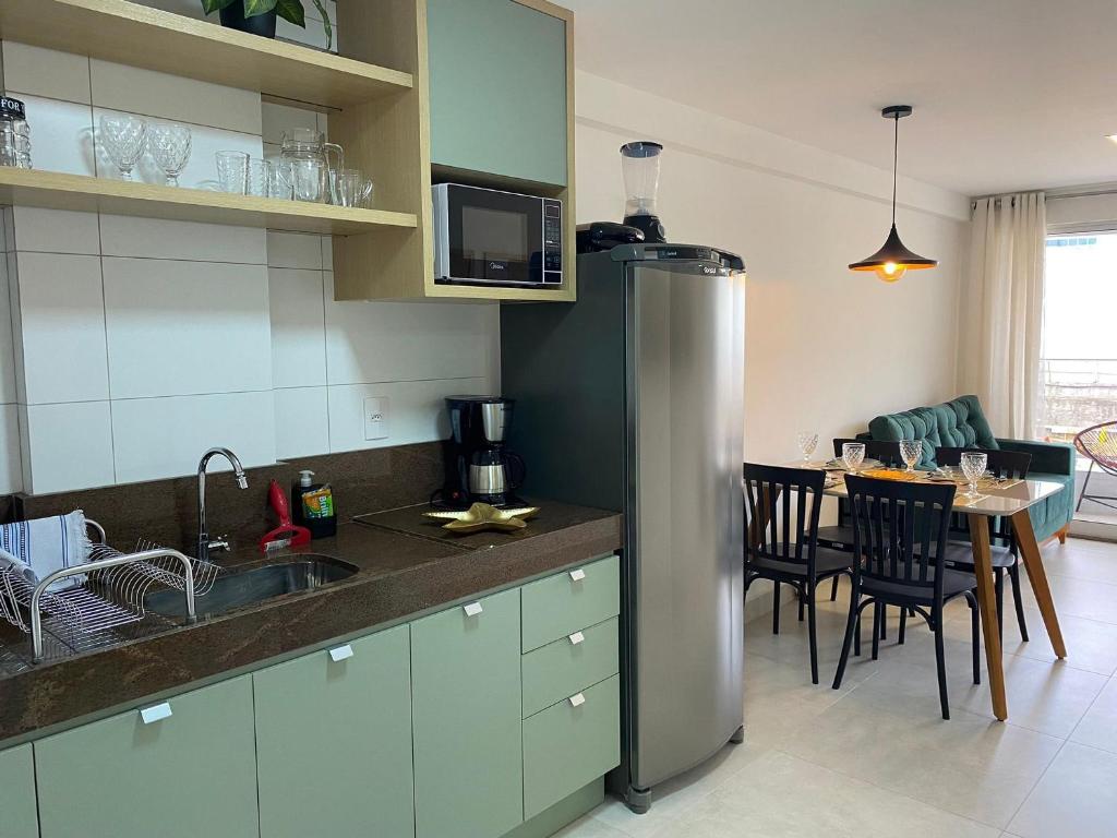 a kitchen with a stainless steel refrigerator and a table at Bela Hospedagem - #Puerto Ventura 103A Beira Mar in João Pessoa