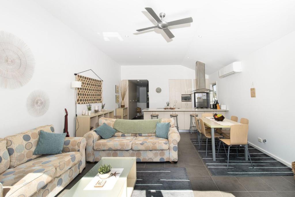sala de estar con 2 sofás y cocina en Swan Lake Retreat, en Berrara