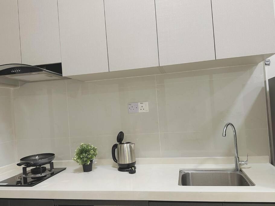 a white kitchen with a sink and a stove at High Rise Horizon City View Apt 4K Netflix in Johor Bahru