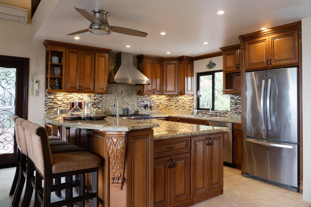 a kitchen with wooden cabinets and a stainless steel refrigerator at Stunning Home & Spectacular View in La Mesa