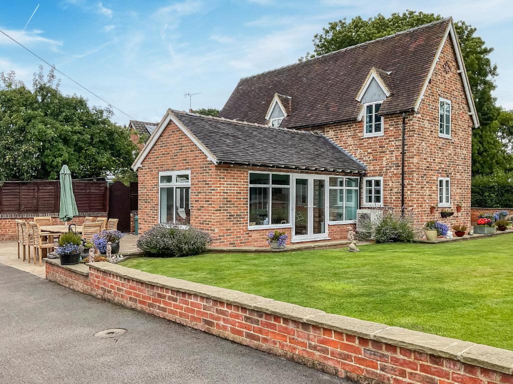 a brick house with a lawn in front of it at The Old Vicarage in Stowe