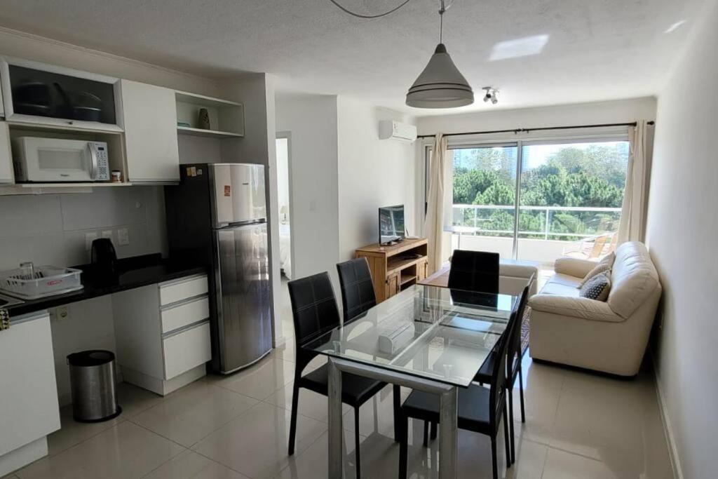 cocina con mesa de cristal y sillas en una habitación en Moderno apartamento con Amenities, en Punta del Este