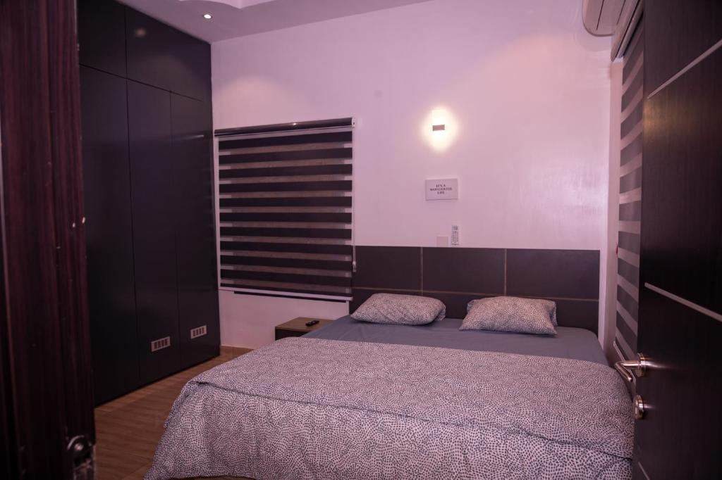 um quarto com uma cama num quarto em Maydec+ Apartment em Jidu