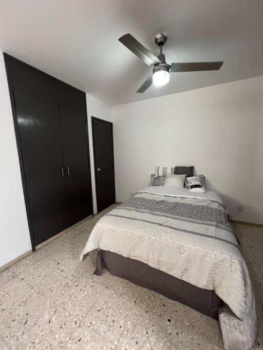 Schlafzimmer mit einem Bett und einem Deckenventilator in der Unterkunft Cómodo Departamento en Providencia in Guadalajara