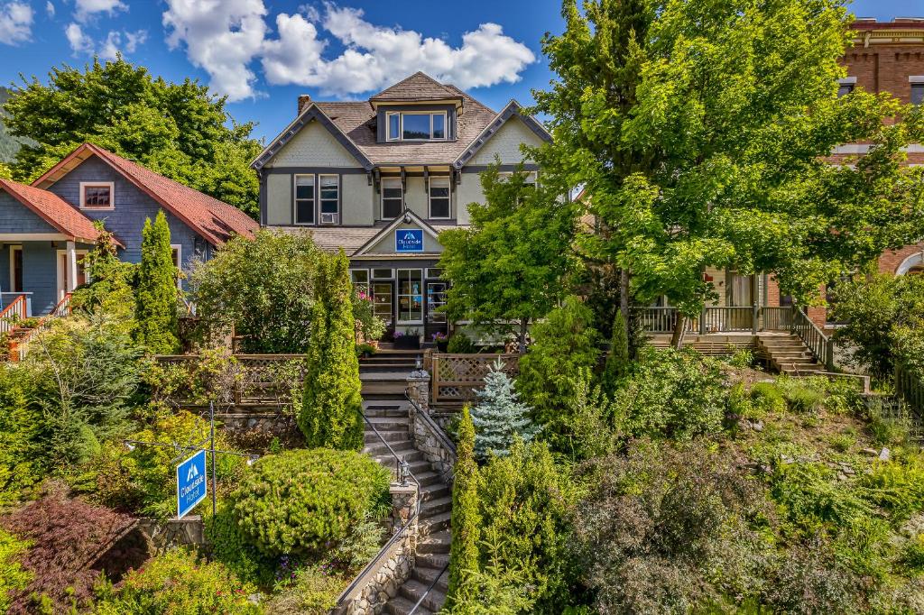 a house on a hill with trees and bushes at Cloudside Hotel in Nelson