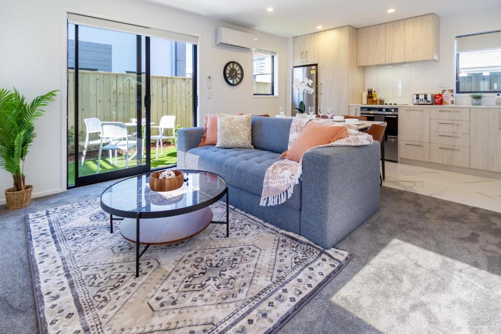 a living room with a blue couch and a table at Beachside Bliss: 1 Bed 1 Bath in Christchurch