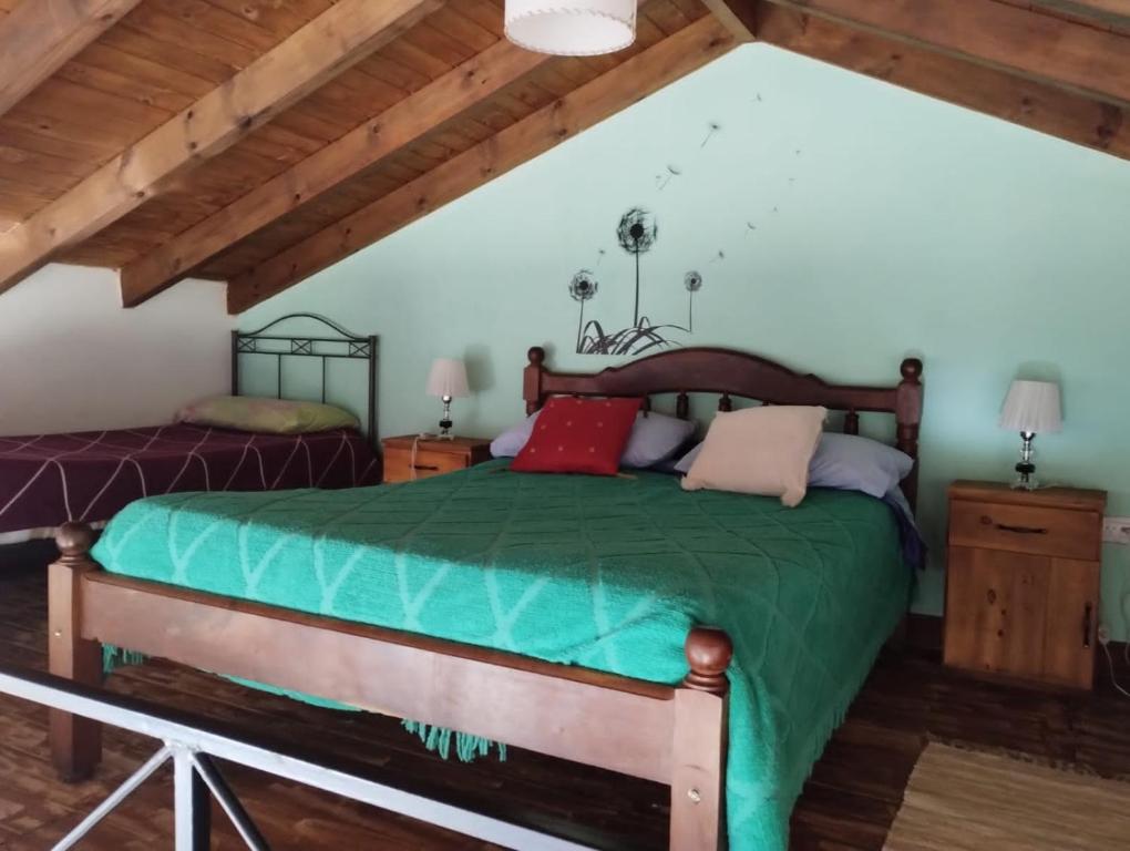 Un dormitorio con una cama verde en un ático en Rincón del Sol en Gardey