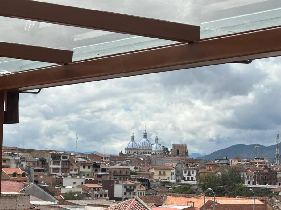 a view of a city from a window at Sucre Suites Cuenca in Cuenca