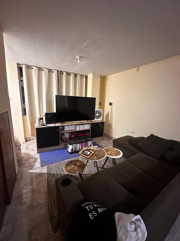 een woonkamer met een bank en een flatscreen-tv bij Casa Juancho in Chiclayo