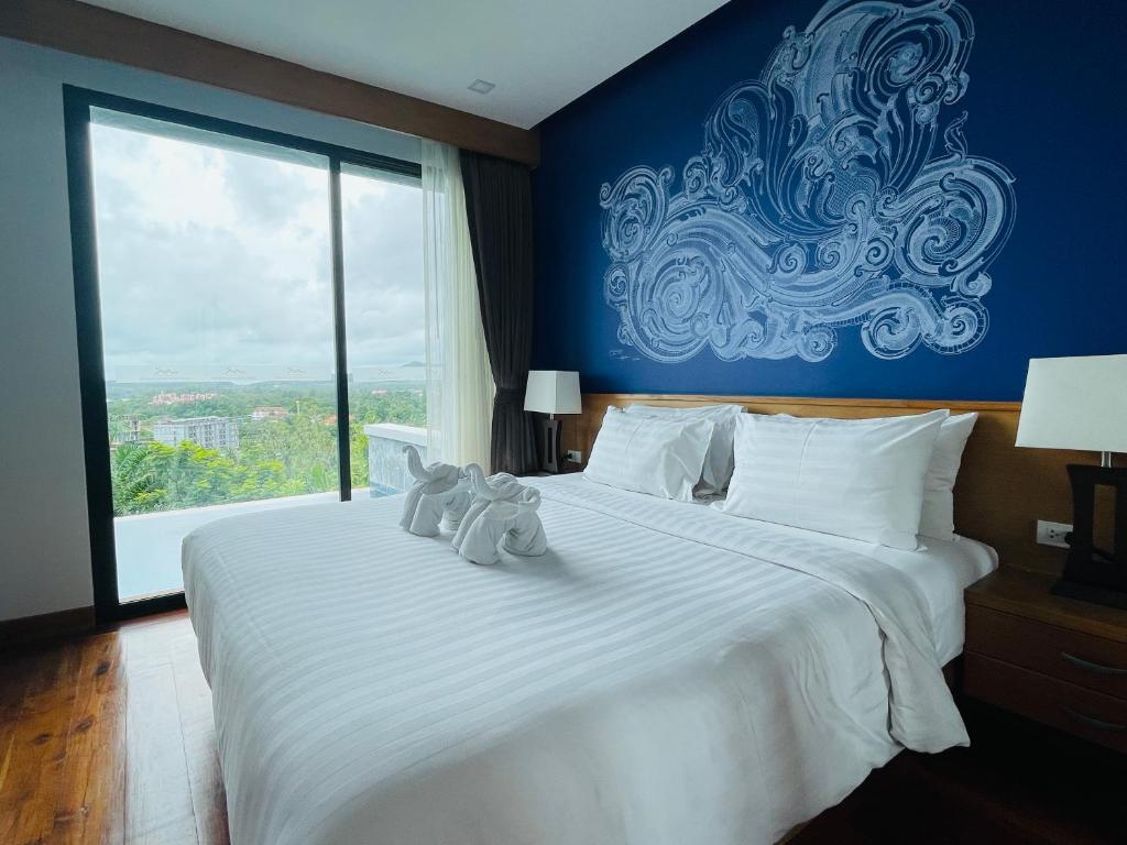 a bedroom with a large white bed with two stuffed animals on it at Aonang Suite Pool Villa in Ao Nang Beach