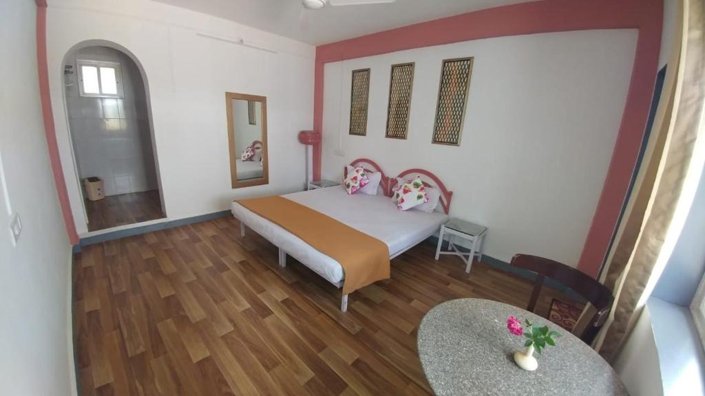 1 dormitorio con 1 cama y 1 mesa en Tabletop Villa Standard - 2, en Panchgani