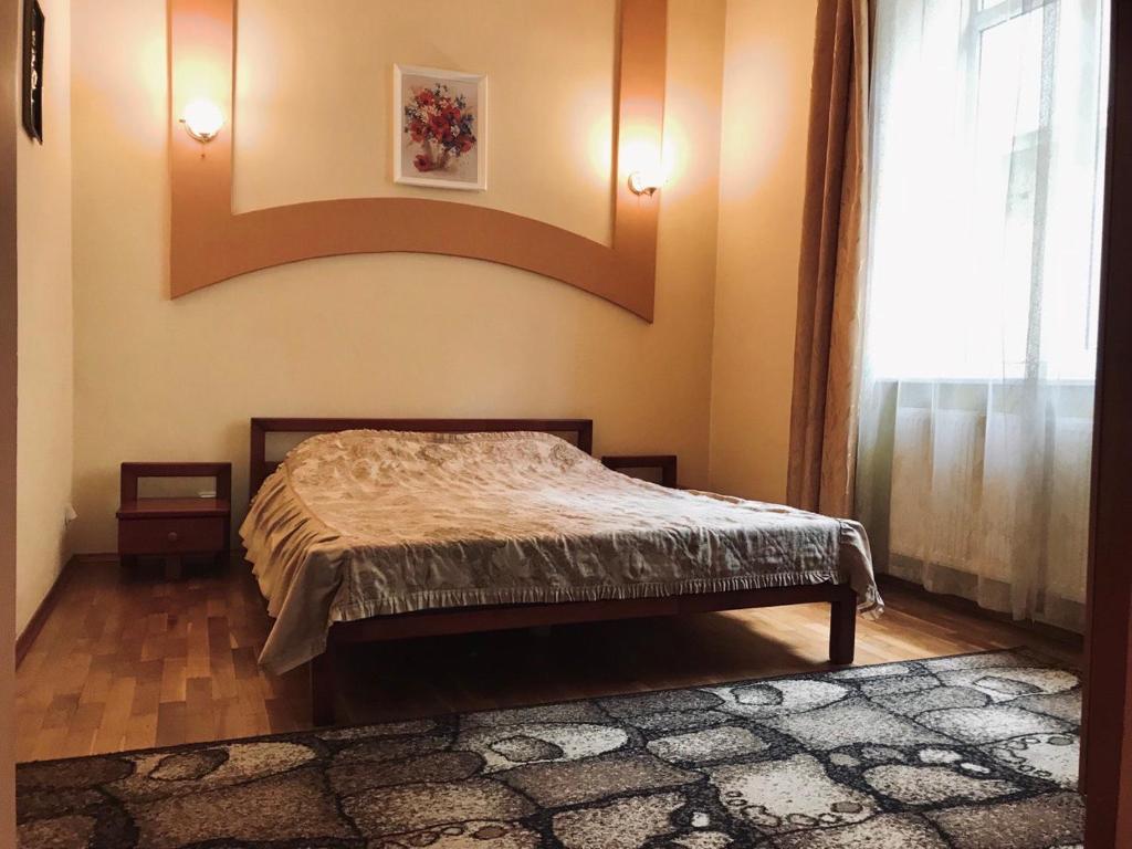1 dormitorio con cama y ventana grande en Apartament-Minihotel Elpida, en Leópolis