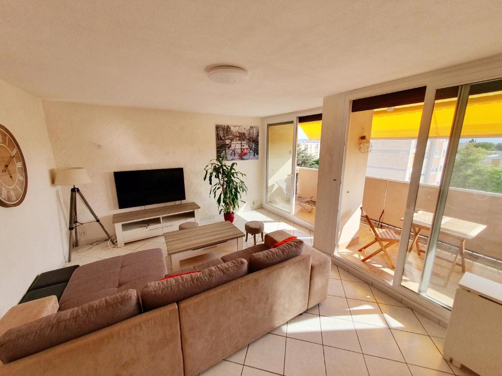 sala de estar con sofá y TV en Appart 70m² plein sud, en Marignane