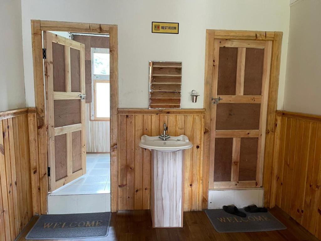 a bathroom with a sink and two open doors at Kongde Peak Guest House in Phakding