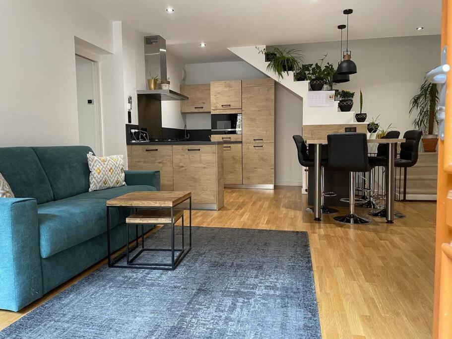 un soggiorno con un divano blu e una cucina di Maison moderne au calme a Saint-Vallier