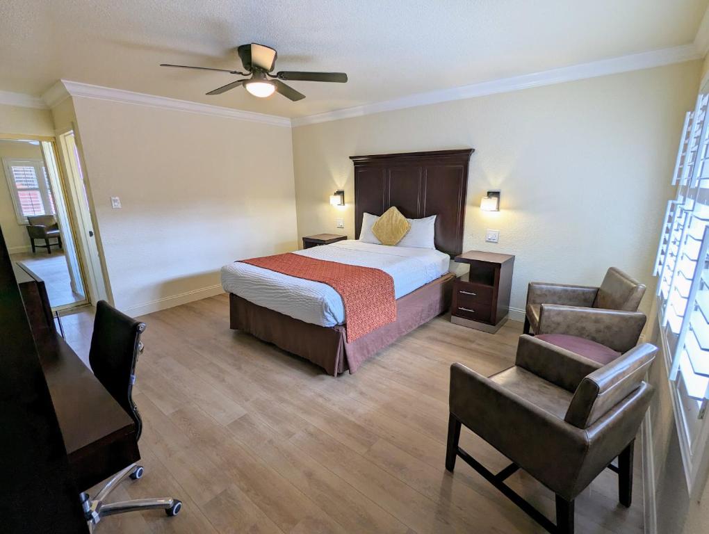 a hotel room with a bed and a chair at Clarion Collection Wilkie's Inn Pacific Grove - Monterey in Pacific Grove