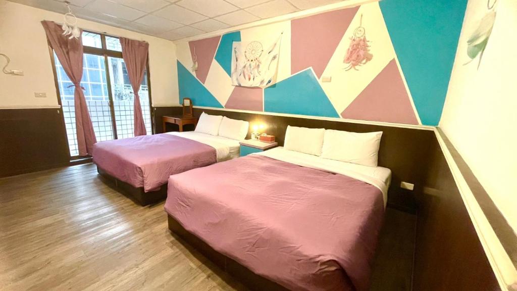 逸仙溫泉旅宿Yi-Shian Hotsprin House في Wenquan: سريرين في غرفة وردية وأرجوانية