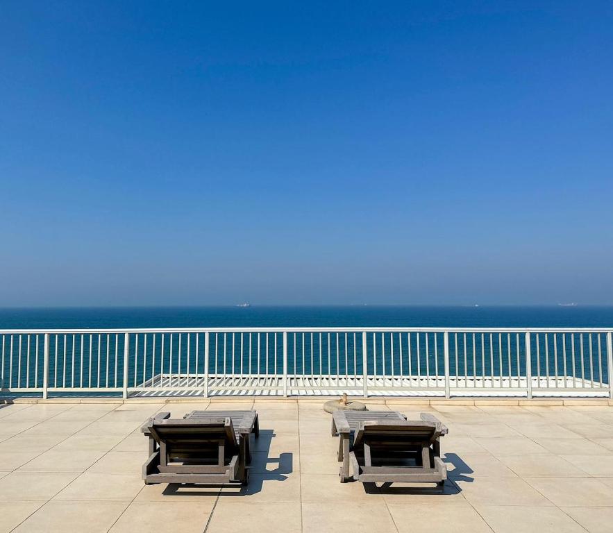 three tables on a balcony with the ocean in the background at 101 Camarque - Beachfront Apartment in Umdloti