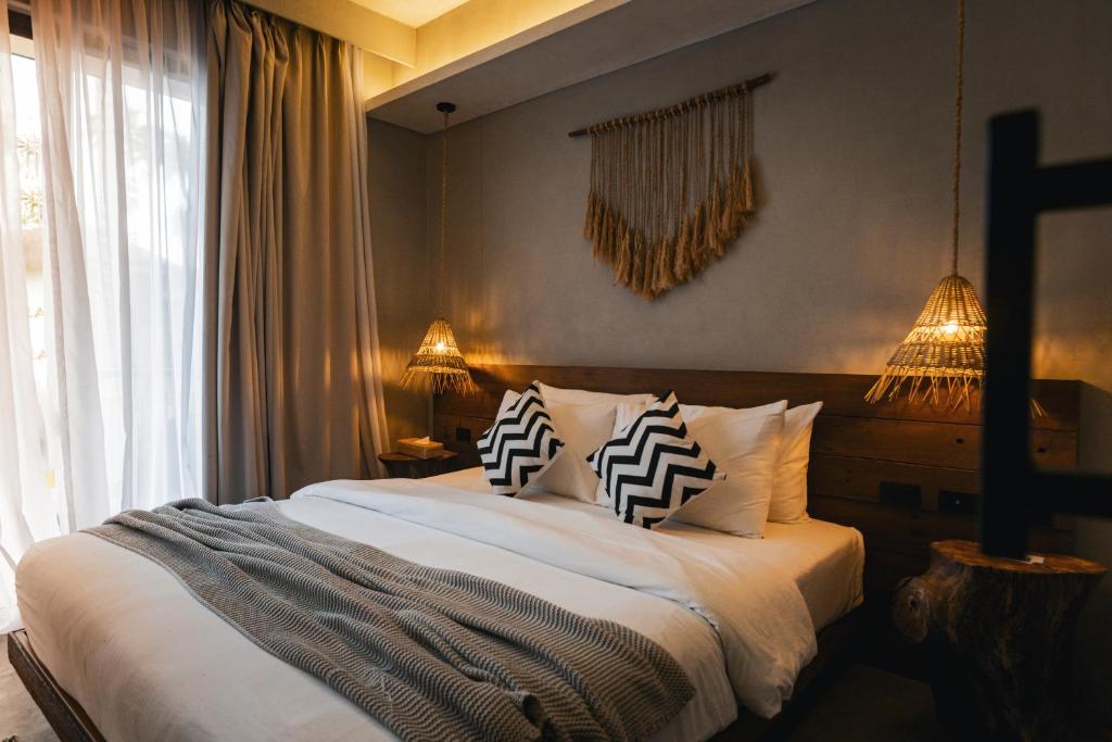 a bedroom with a bed with two pillows on it at Isla Amara Resort in El Nido