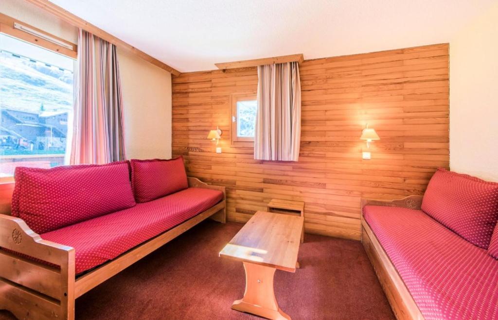 a room with two red couches and a table at Quartier Crève Cœur - maeva Home - 2 Pièces 5 Personnes Confort 74 in Valmorel