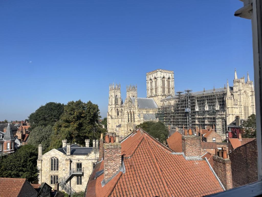 Blick auf eine Stadt mit Dächern und eine Kathedrale in der Unterkunft Minster View Penthouse in York